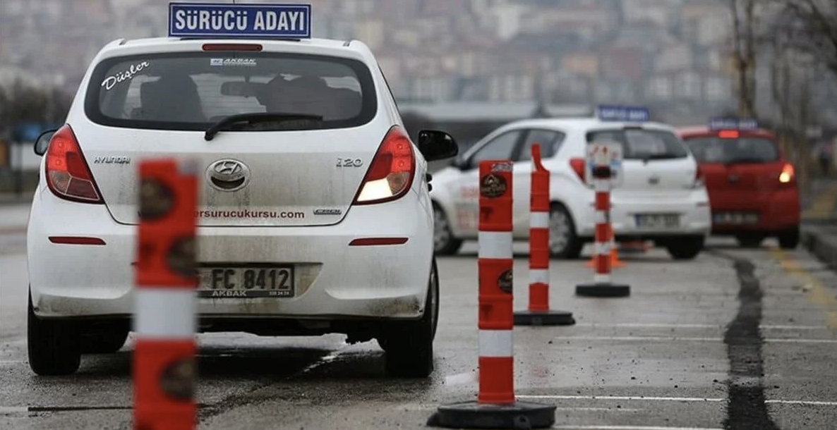 Direksiyon sınavında koni arasında manevra yapan sürücü adayı aracı